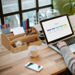 Woman working on laptop with white screen in modern office.