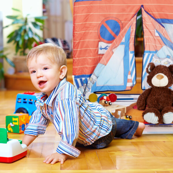 two cute baby boys playing with toys at home