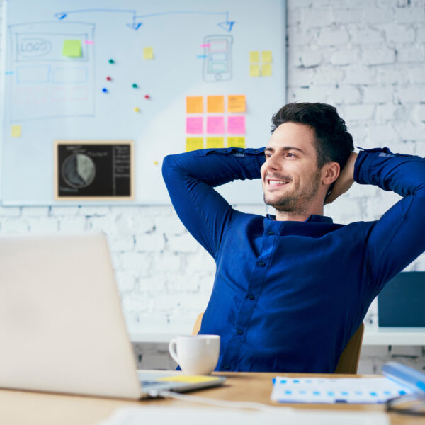 Satisfied young man in office looking away