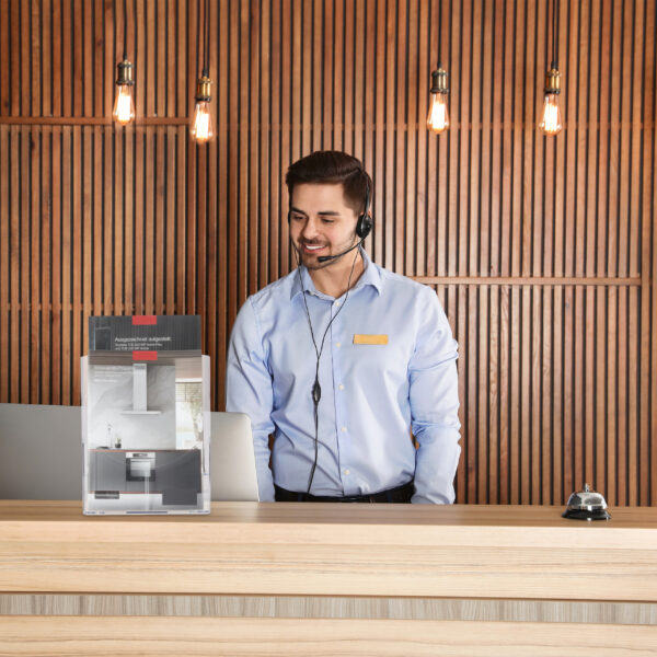 Portrait of receptionist with headset at desk in lobby
