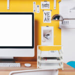 Modern creative workspace on yellow wall.