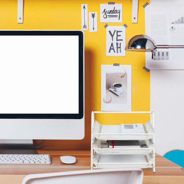 Modern creative workspace on yellow wall.