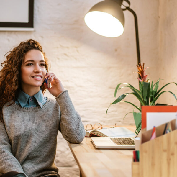 Attractive young woman talking on the mobile phone and smiling w