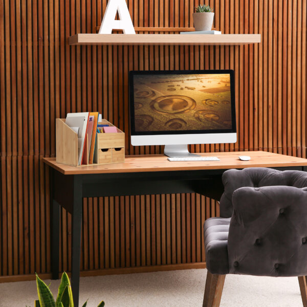 Comfortable workplace with computer near wooden wall in stylish