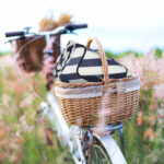 Bicycle retro with basket picnic and guitar of flowers in meadow