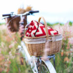 Bicycle retro with basket picnic and guitar of flowers in meadow
