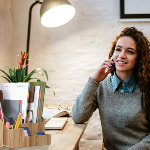 Young charming woman calling with cell telephone while sitting a