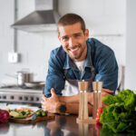 Happy man ready to cook in kitchen