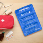 First aid kit on light wooden table, flat lay. Space for text