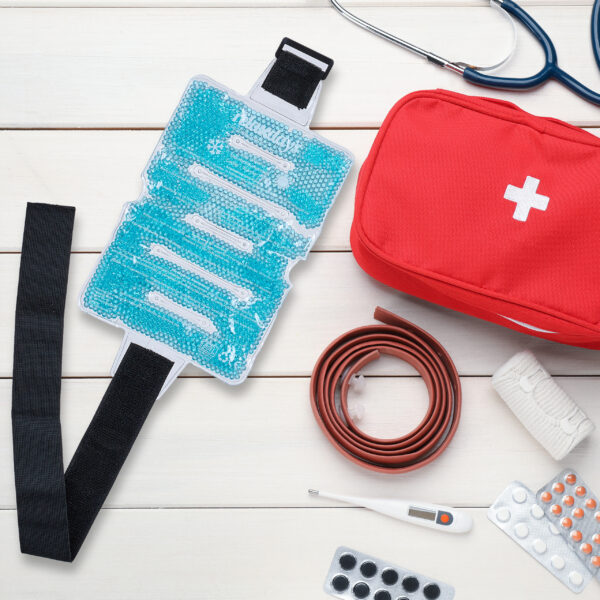 Flat lay composition with first aid kit on white wooden table, s