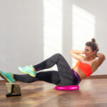 Diligent cheerful fit woman with bun hairstyle and in tight spor