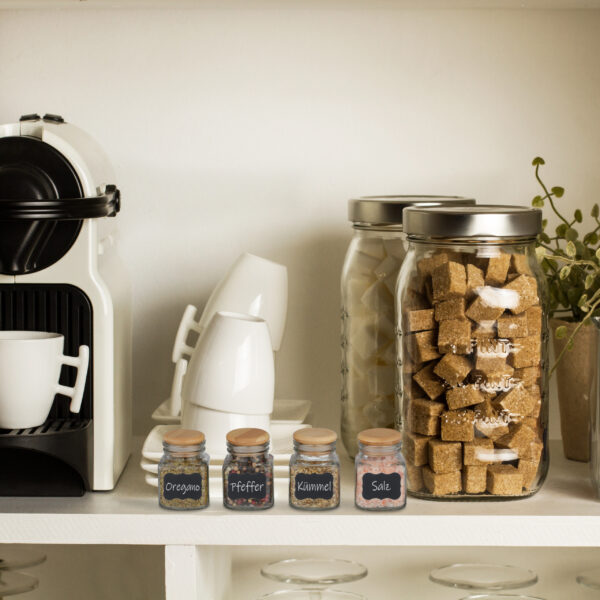 Cafetera automática con tazas de café, azúcar en terrones en