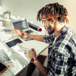 Interior designer with dreadlocks wearing red headband drawing sketches