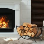 Firewood in wicker basket near fireplace indoors