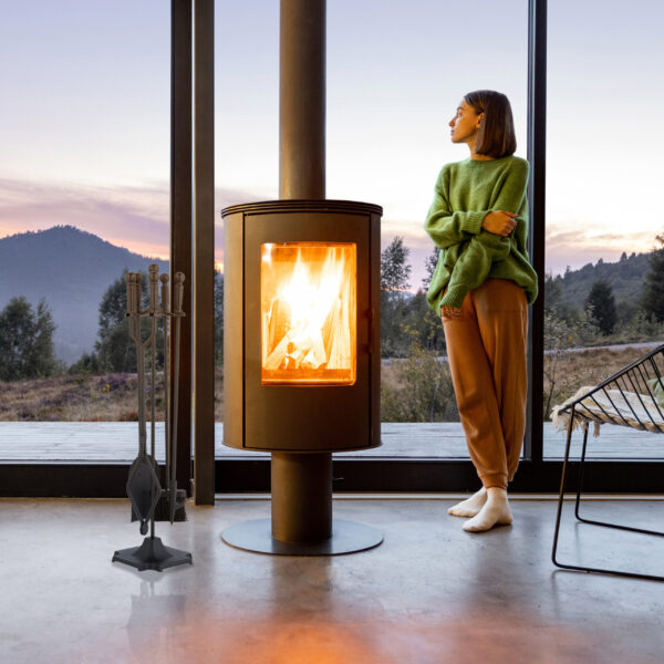 Woman enjoy great view on mountains while standing at home near fireplace